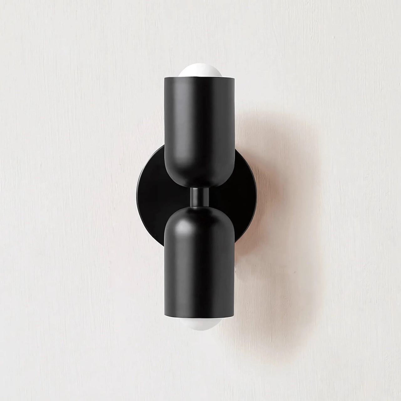 Black wall-mounted light fixture on a white background