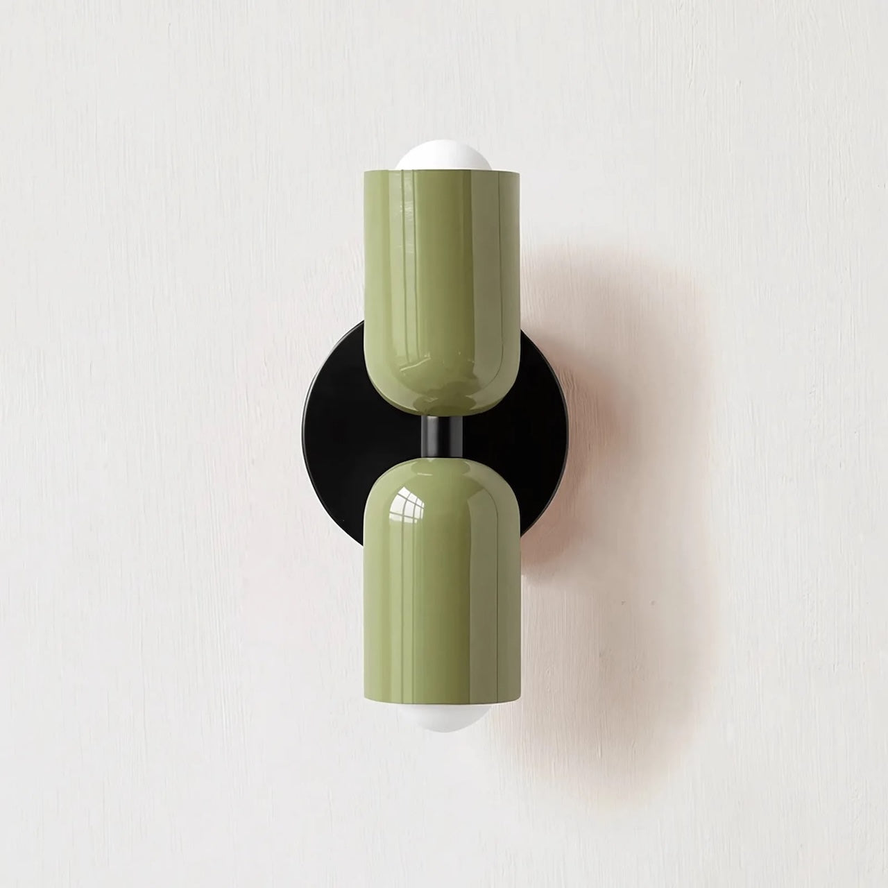 Wall-mounted lamp with green cylindrical design on a white background