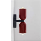 Modern wall sconce with red glass shades on a white background